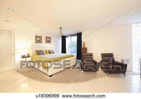 Stock Photo - Partly carpeted bedroom with matching leather armchairs. Fotosearch