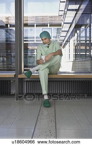 Pensive Physician having coffee in hospital corridor View Large Photo Image Stock Photograph - Pensive Physician having coffee in hospital corridor. Fotosearch