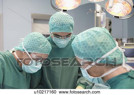 Physicians in Surgery looking down at patient View Large Photo Image Stock Image - Physicians in Surgery looking down at patient. Fotosearch