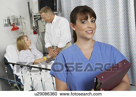 Portrait of female nurse in hospital room, patient in background View Large Photo Image Stock Image - Portrait of female nurse in hospital room, patient in background. Fotosearch