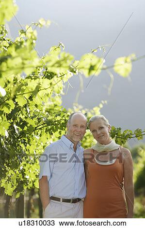Stock Image - Portrait of mature couple at the vineyard. Fotosearch