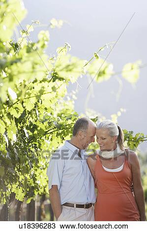 Stock Image - Portrait of mature couple at the vineyard. Fotosearch