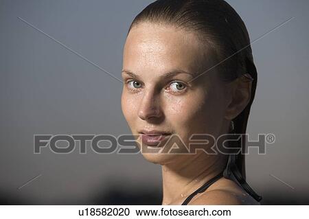 Stock Image - Portrait of young woman in swimming costume at dusk. Fotosearch