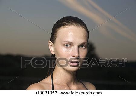 Stock Photo - Portrait of young woman in swimming costume at dusk. Fotosearch