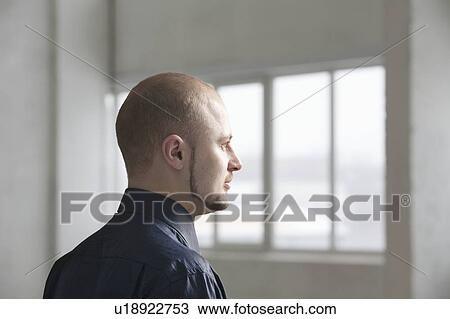 Stock Image - Profile of young businessman in warehouse interior. Fotosearch
