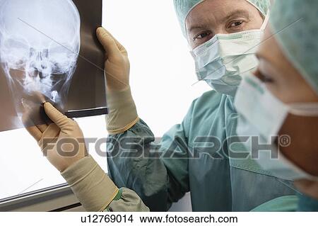 Picture - Radiologists Examining X-Ray of skull. Fotosearch