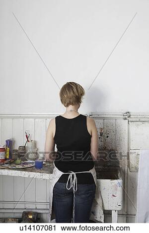 Rear view of young woman cleaning paintbrushes at sink View Large Photo Image Stock Image - Rear view of young woman cleaning paintbrushes at sink. Fotosearch