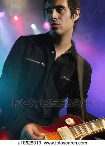 Rock Guitarist on stage in Concert, close up, low angle view View Large Photo Image Stock Photo - Rock Guitarist on stage in Concert, close up, low angle view. Fotosearch