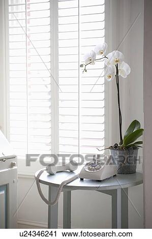 Stock Image - Rotary phone off the hook on a side table in London. Fotosearch