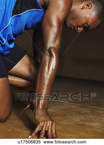 Stock Photography - Runner crouching down, side view. Fotosearch