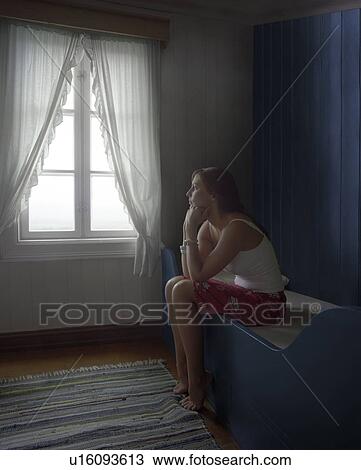 Sad Woman Sitting Alone in Room, daydreaming, side view View Large Photo Image Stock Image - Sad Woman Sitting Alone in Room, daydreaming, side view. Fotosearch