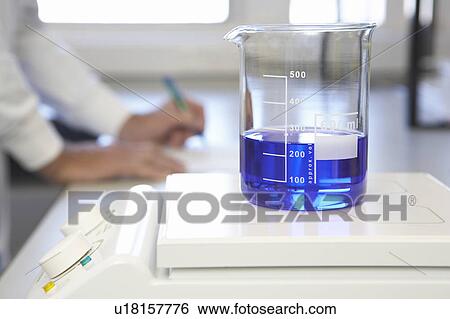 Scientific glass container with blue liquid on scales View Large Photo Image Stock Photograph - Scientific glass container with blue liquid on scales. Fotosearch