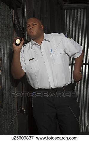 Security guard investigates with torch View Large Photo Image Stock Photo - Security guard investigates with torch. Fotosearch