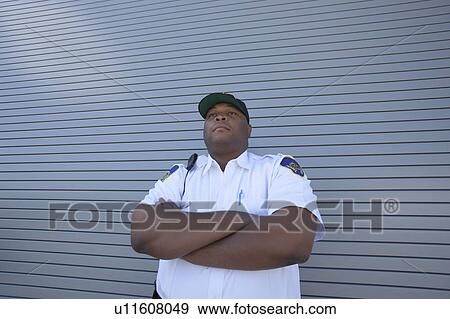 Security guard protects doorway with arms folded View Large Photo Image Stock Photo - Security guard protects doorway with arms folded. Fotosearch