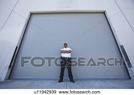 Security guard protects warehouse entrance View Large Photo Image Stock Photo - Security guard protects warehouse entrance. Fotosearch