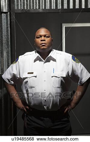 Stock Photo - Security guard stands with hands on hips. Fotosearch