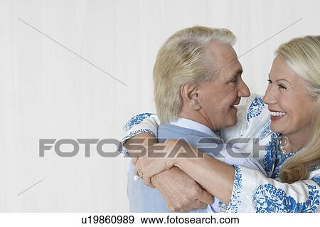 Senior couple embracing in studio, head and shoulders View Large Photo Image Stock Photo - Senior couple embracing in studio, head and shoulders. Fotosearch