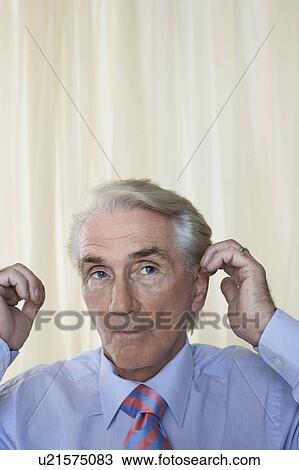 Stock Image - Senior Man fixing hair, head and shoulders. Fotosearch