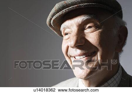 Stock Image - Senior man in flat cap, close up, in studio. Fotosearch