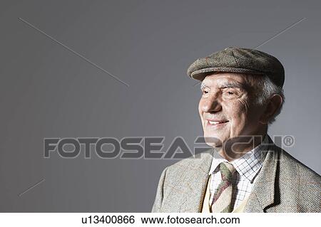 Stock Photograph - Senior man in flat cap, head and shoulders, in studio. Fotosearch