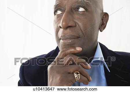 Stock Photo - Senior Man in studio, head and shoulders, hand on chin. Fotosearch