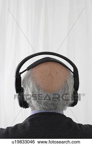 Senior man wearing head phones in studio, head and shoulders, back view View Large Photo Image Stock Photograph - Senior man wearing head phones in studio, head and shoulders, back view. Fotosearch