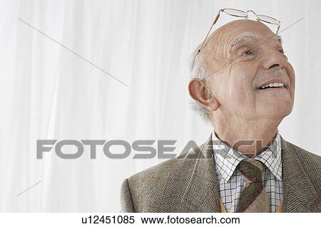 Stock Photography - Senior man with glasses on head in studio, head and shoulders. Fotosearch
