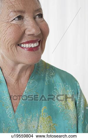 Senior woman in dressing gown in studio, head and shoulders View Large Photo Image Picture - Senior woman in dressing gown in studio, head and shoulders. Fotosearch
