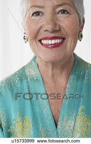 Stock Photo - Senior woman in dressing gown in studio, head and shoulders. Fotosearch