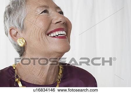 Stock Photograph - Senior woman in studio, head and shoulders, looking up. Fotosearch