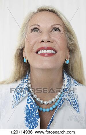 Senior woman in studio, head and shoulders, looking up View Large Photo Image Stock Photograph - Senior woman in studio, head and shoulders, looking up. Fotosearch