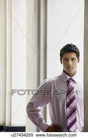 Stock Photography - Serious businessman standing in archway, portrait. Fotosearch