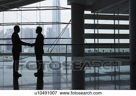 Silhouettes of two business men shaking hands View Large Photo Image Stock Photo - Silhouettes of two business men shaking hands. Fotosearch