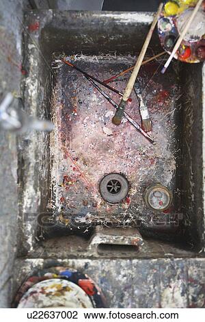 Stock Image - Sink with palette and paintbrushes in artist's studio, view from above. Fotosearch