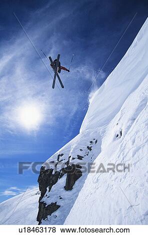 Skier jumping from mountain ledge View Large Photo Image Stock Photo - Skier jumping from mountain ledge. Fotosearch
