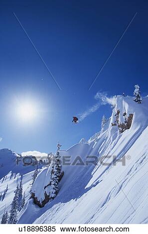 Skier jumping from mountain ledge View Large Photo Image Stock Photography - Skier jumping from mountain ledge. Fotosearch