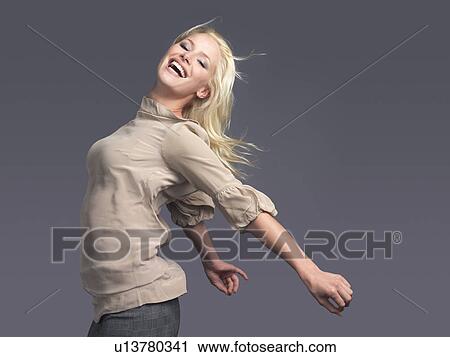 Smiling woman standing, arms outspread, side view View Large Photo Image Stock Image - Smiling woman standing, arms outspread, side view. Fotosearch