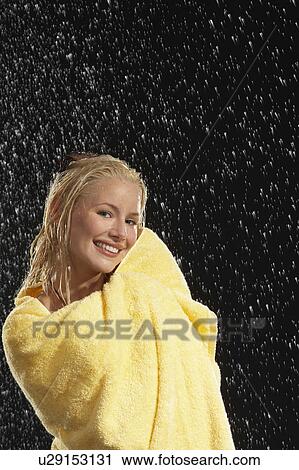 Stock Image - Smiling Woman Wrapped in Towel Standing in Rain. Fotosearch
