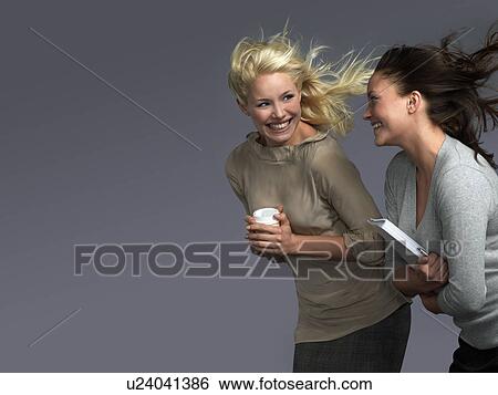Stock Photograph - Smiling women Facing the Wind, hair billowing behind. Fotosearch