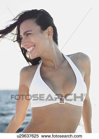 Smiling young woman in bikini against sea View Large Photo Image Stock Photography - Smiling young woman in bikini against sea. Fotosearch