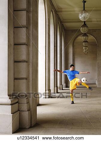 Soccer player kicking ball in portico View Large Photo Image Stock Image - Soccer player kicking ball in portico. Fotosearch