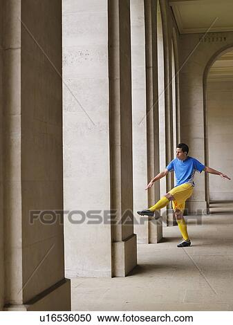 Soccer player kicking ball in portico View Large Photo Image Stock Image - Soccer player kicking ball in portico. Fotosearch