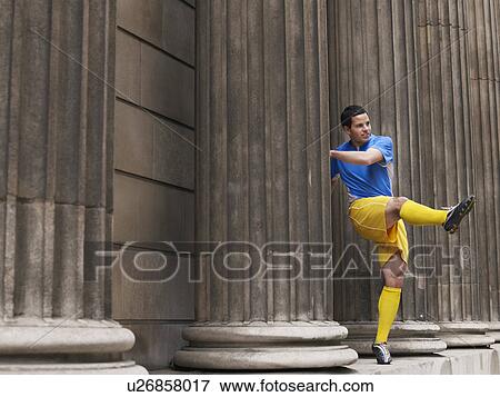Soccer player kicking ball, standing between columns View Large Photo Image Stock Photo - Soccer player kicking ball, standing between columns. Fotosearch