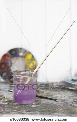 Still life of paintbrush resting in jar of purple water View Large Photo Image Stock Photo - Still life of paintbrush resting in jar of purple water. Fotosearch