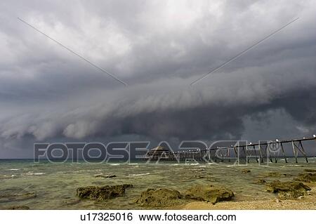 Stock Photograph - Storm clouds over pier at Japmala Resort, Tioman Island in Malaysia. Fotosearch