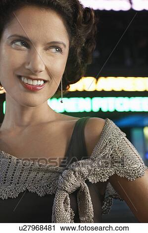 Stock Image - Stylish Woman on Sidewalk, at night, close up. Fotosearch