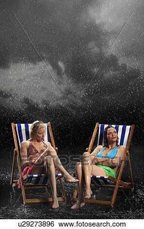 Sunbathers sitting in sunloungers during downpour View Large Photo Image Stock Photograph - Sunbathers sitting in sunloungers during downpour. Fotosearch