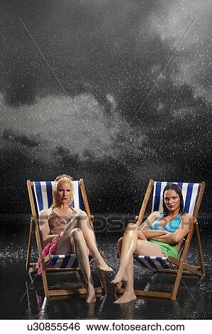 Sunbathers sitting in sunloungers during downpour View Large Photo Image Stock Photograph - Sunbathers sitting in sunloungers during downpour. Fotosearch