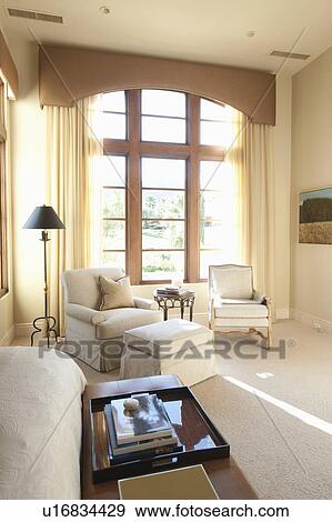 Sunlit floor to ceiling windows in cream living room interior View Large Photo Image Stock Photo - Sunlit floor to ceiling windows in cream living room interior. Fotosearch