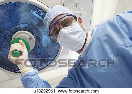 Surgeon adjusting lamp, low angle view View Large Photo Image Stock Image - Surgeon adjusting lamp, low angle view. Fotosearch